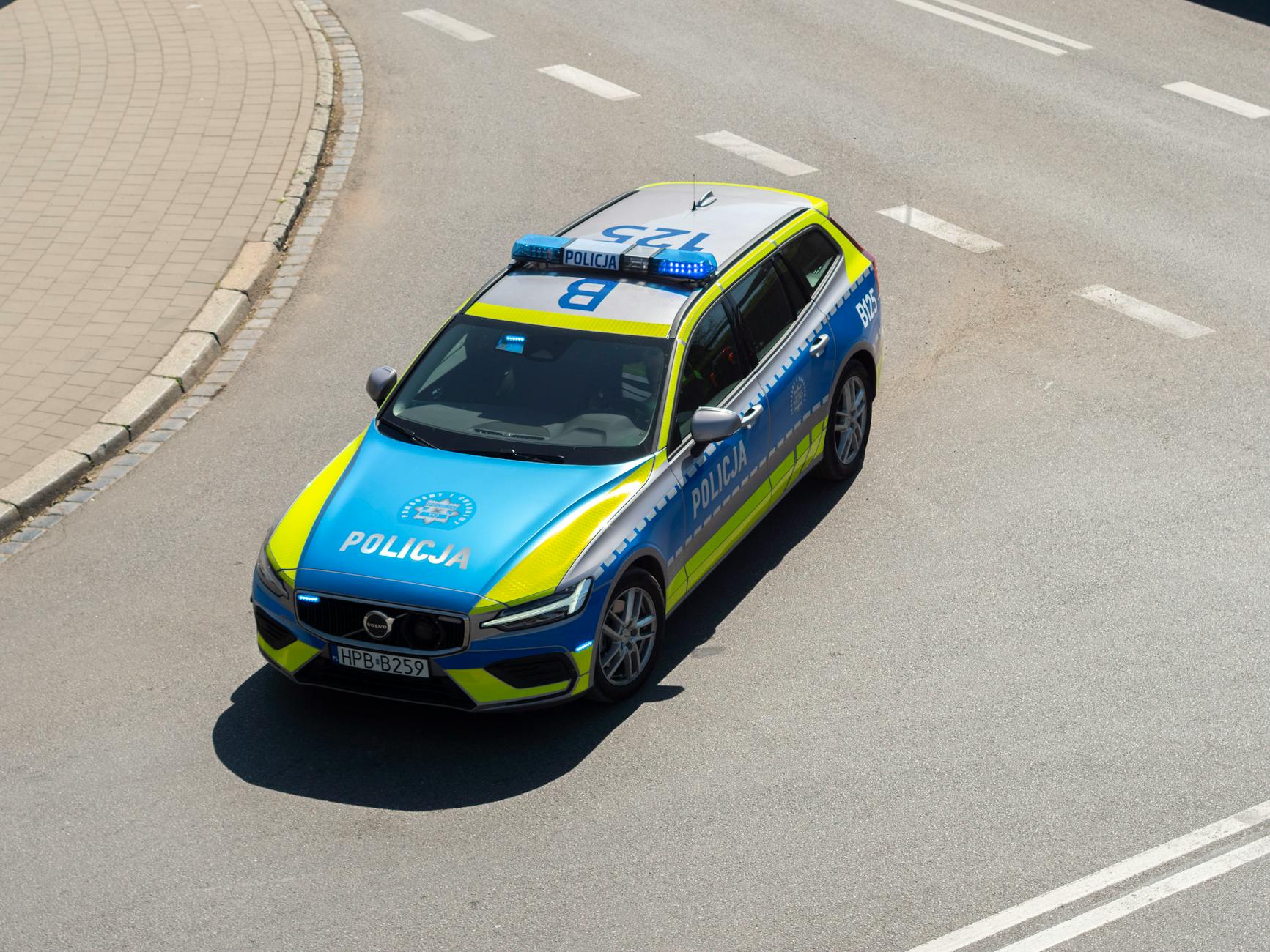 Nowy radiowóz policyjny zaparkowany przed budynkiem komendy w Radzionkowie, symbolizujący poprawę warunków pracy funkcjonariuszy.